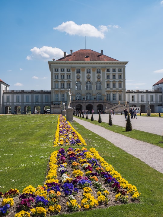 people walking near Nymphenburg Palace in Munich, Germany under blue and white sky in Schlosspark Nymphenburg Germany