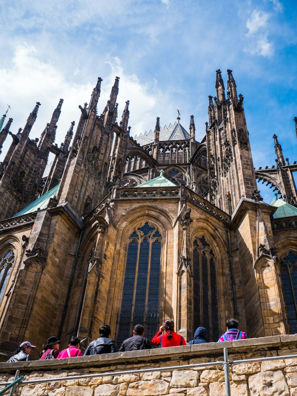 people standing near St. Vitus Cathedral in Prague, Czechia under blue and white sky