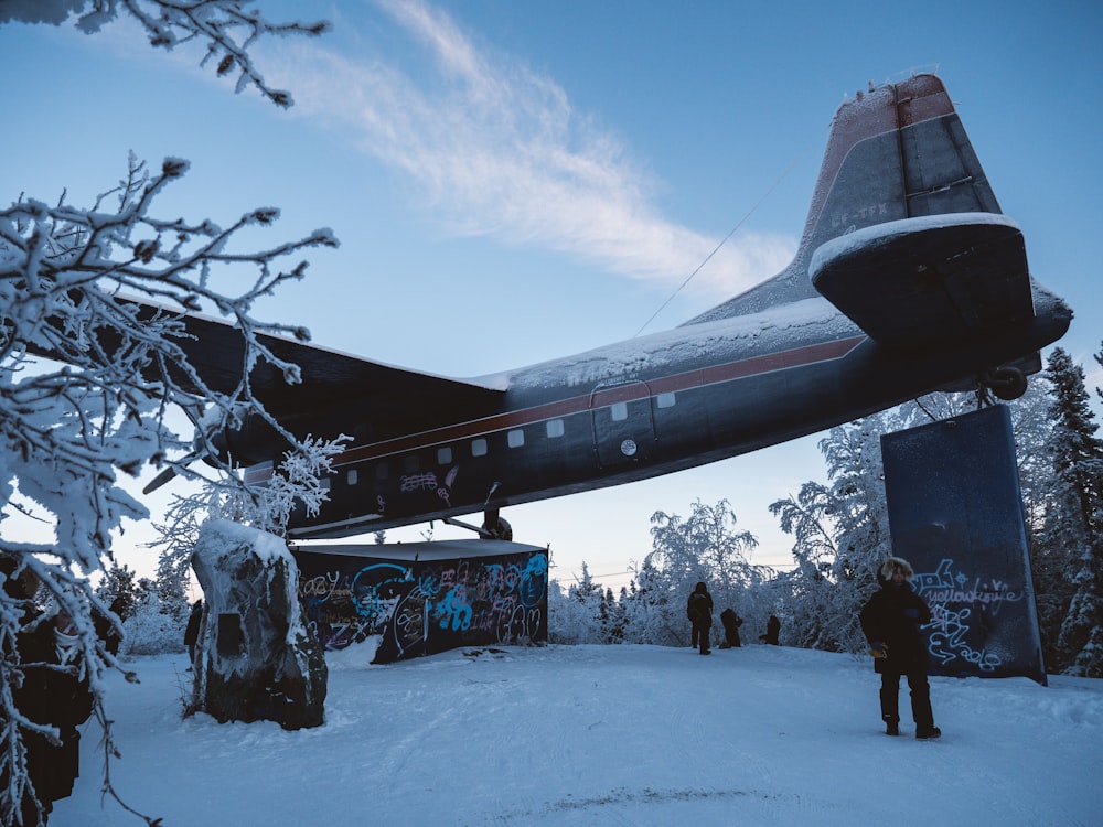 Menschen stehen auf verschneitem Feld unter blau-weißem Himmel