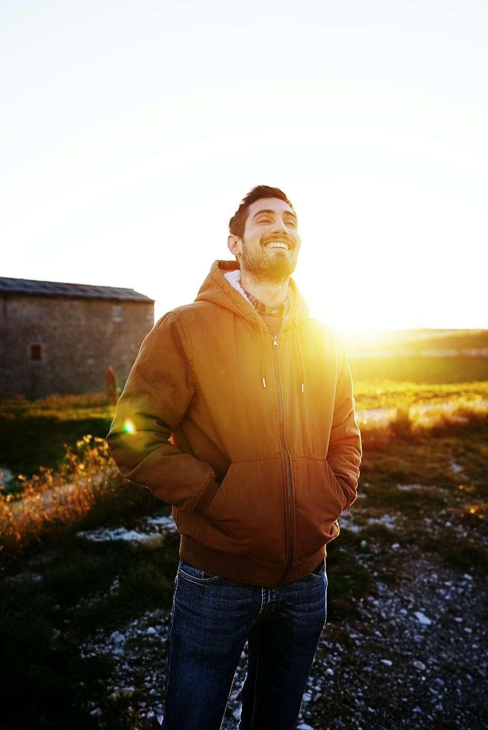 man wearing brown zip-up hoodie and blue denim fitted jeans