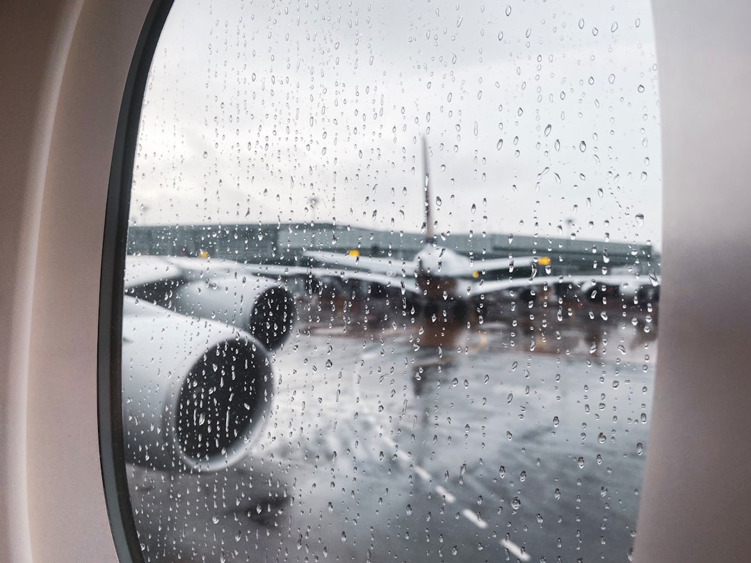 white airplane on railway in rainy day