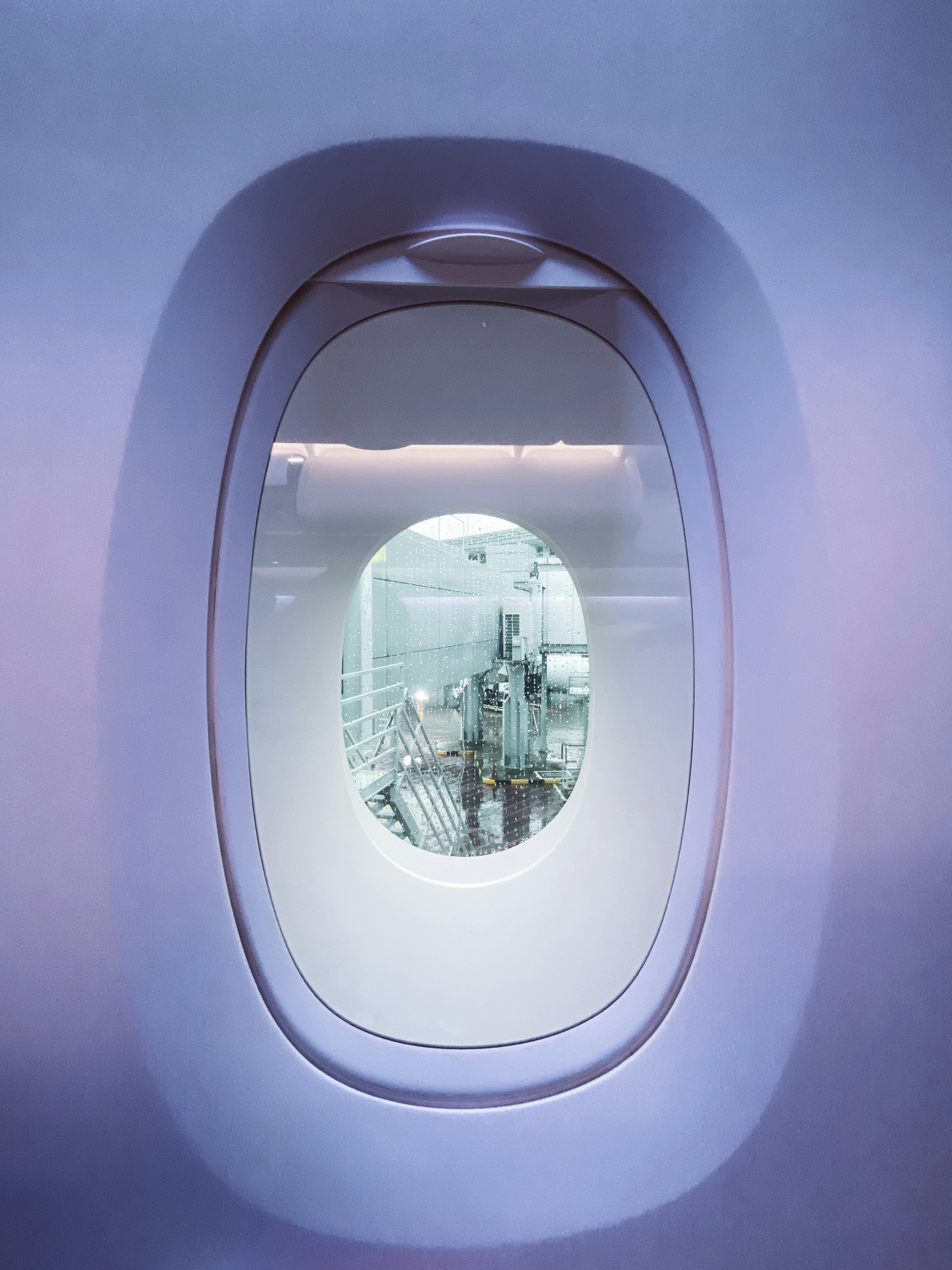An airplane window with a reflection of a building in it photo – Free ...