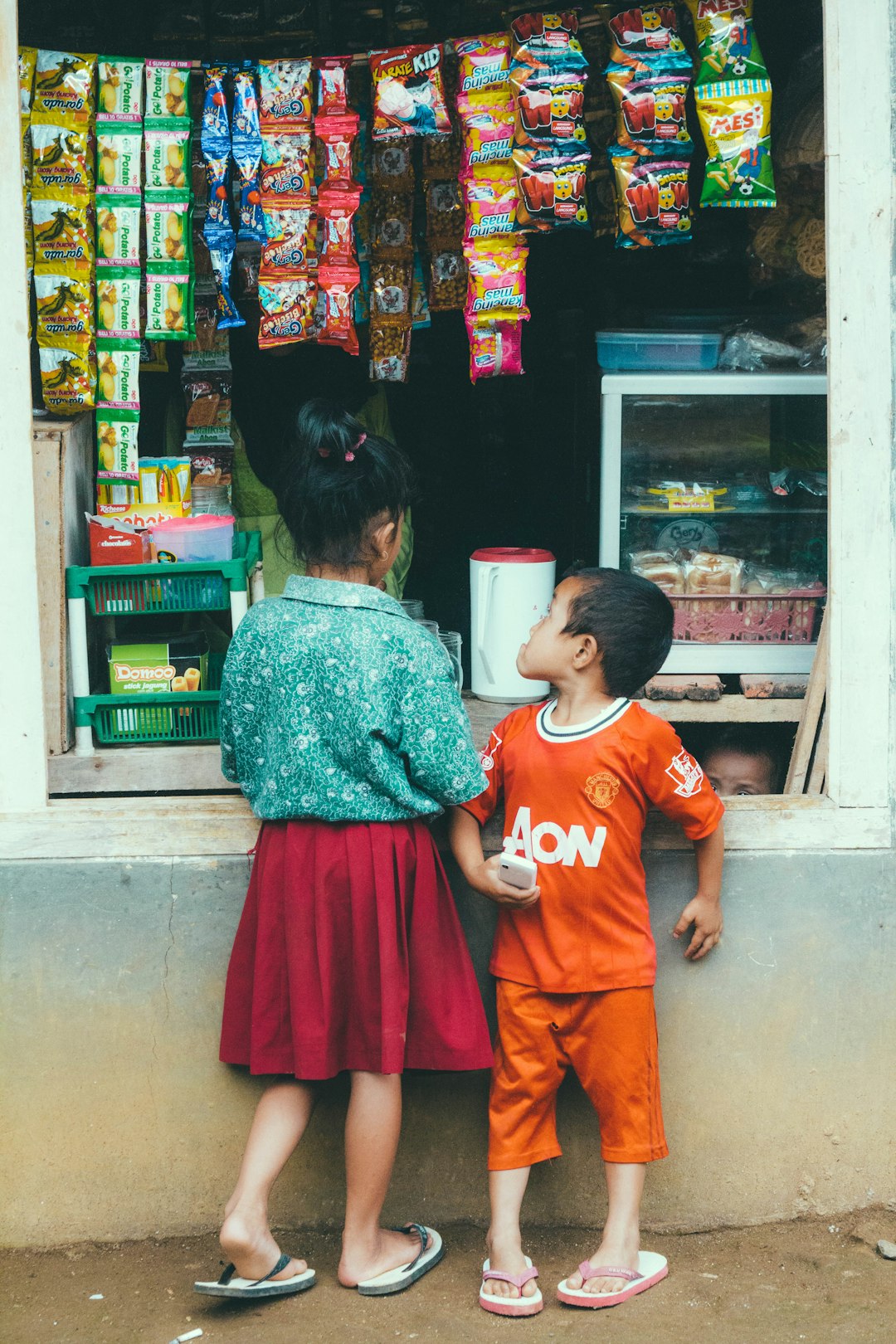 girl and boy standing in front of store
