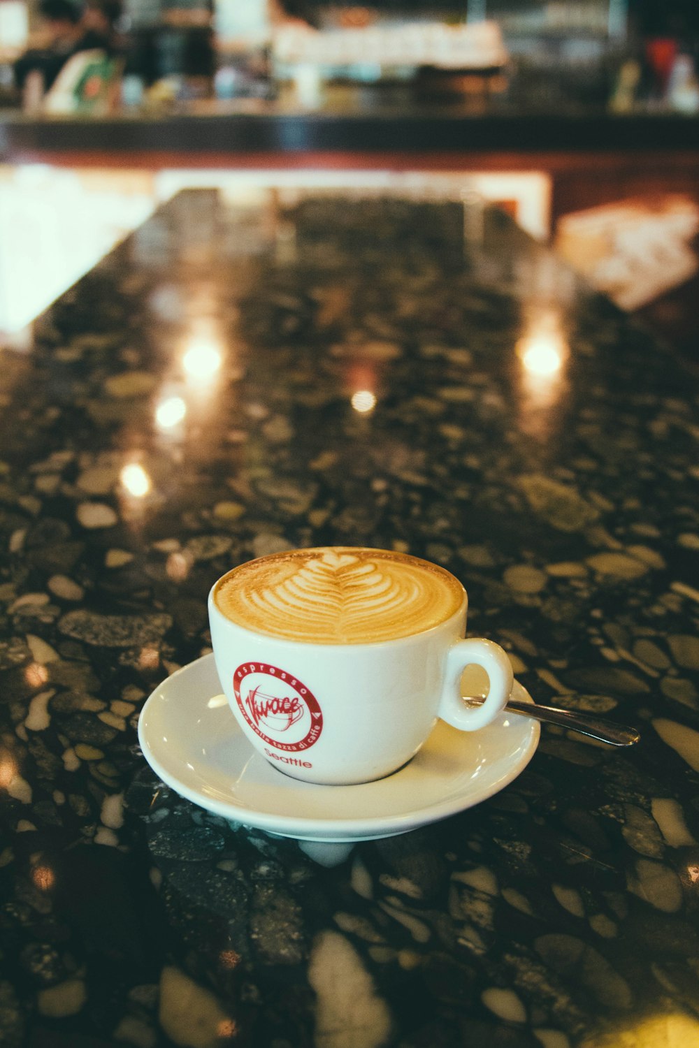 cappuccino in white ceramic mug near spoon