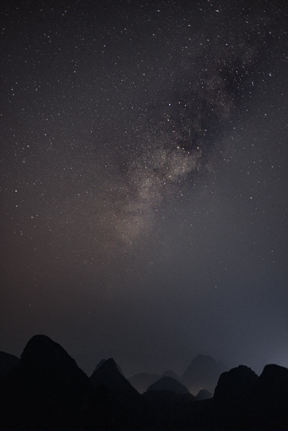 silhouette of mountain viewing sky during night time