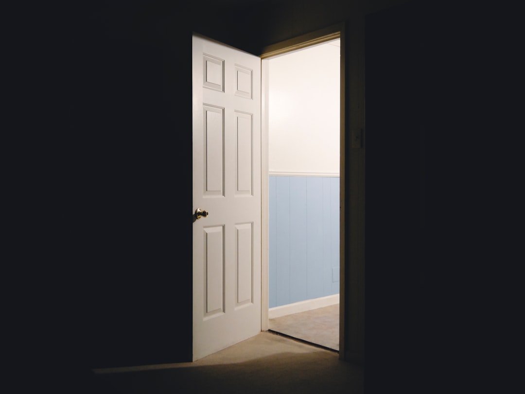 An open door allowing light to shine into a dark room.
