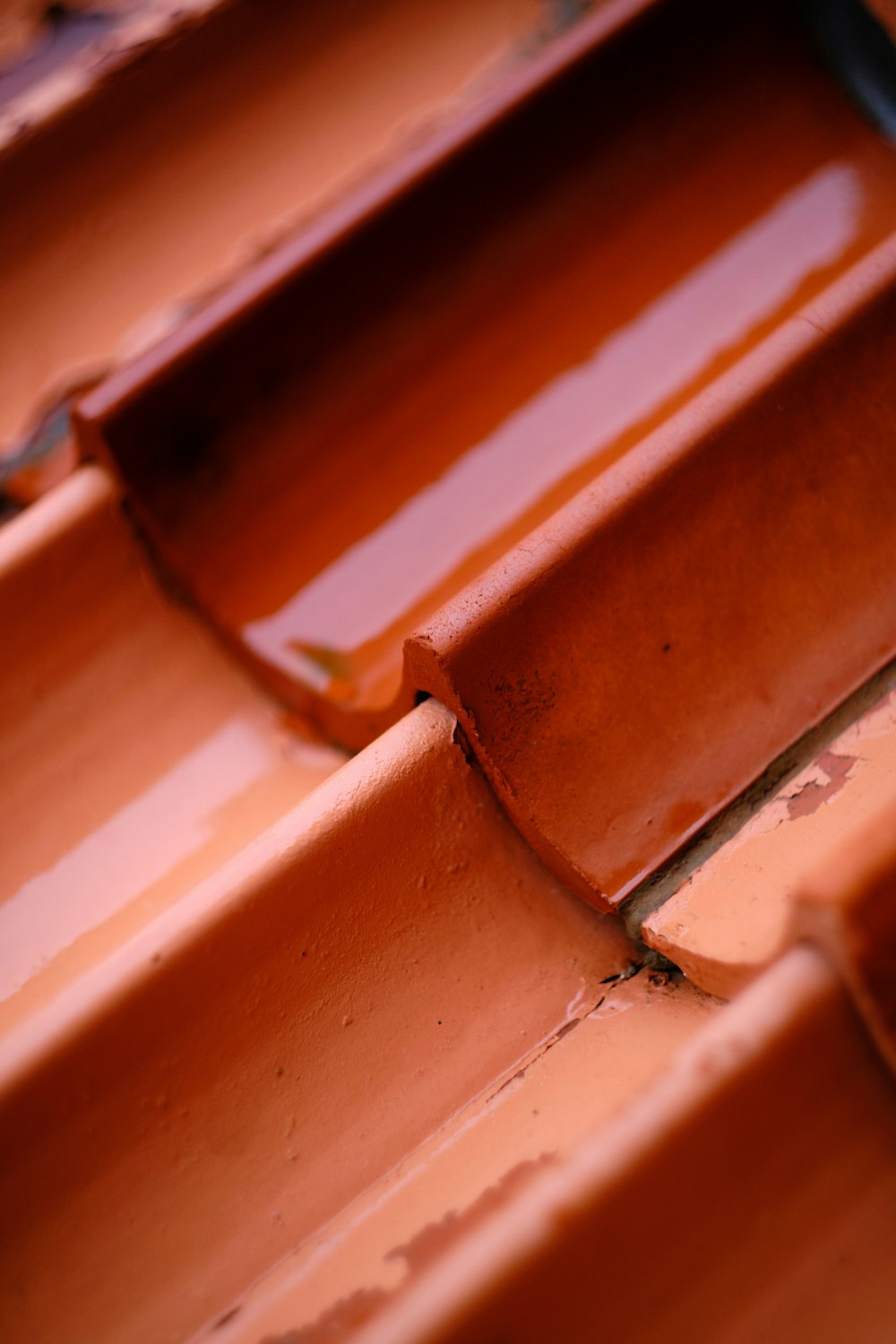 a close up of a wooden bench with brown paint
