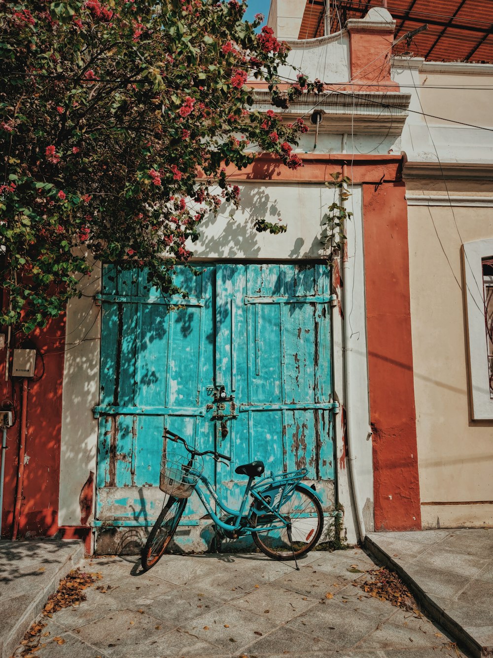 teal road bike in front of closed door