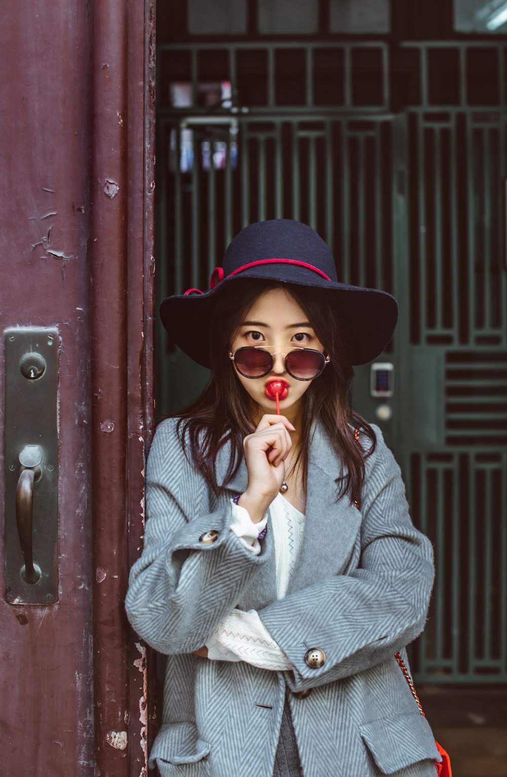 woman eating lollipop near gate