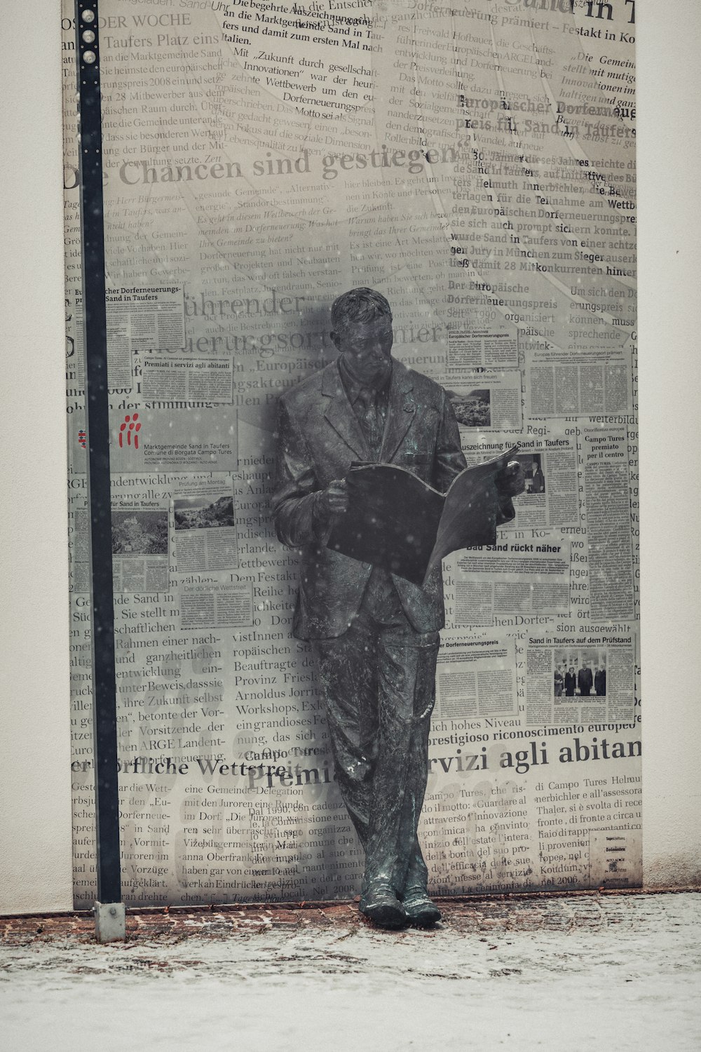man reading book statue during daytime