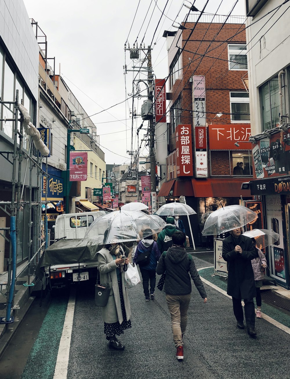 people in street holding umbrellas during daytime