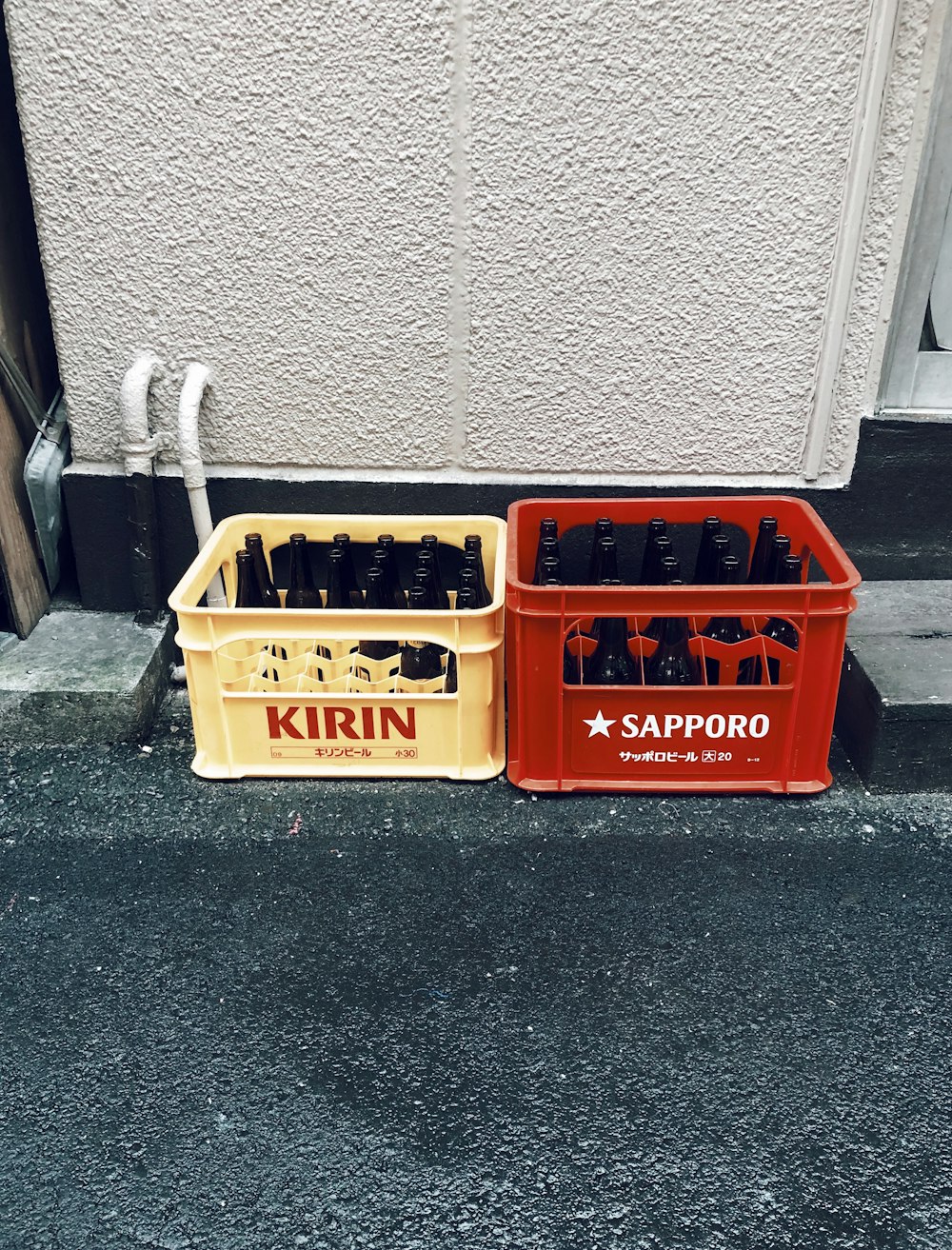 bottles on plastic cases near wall