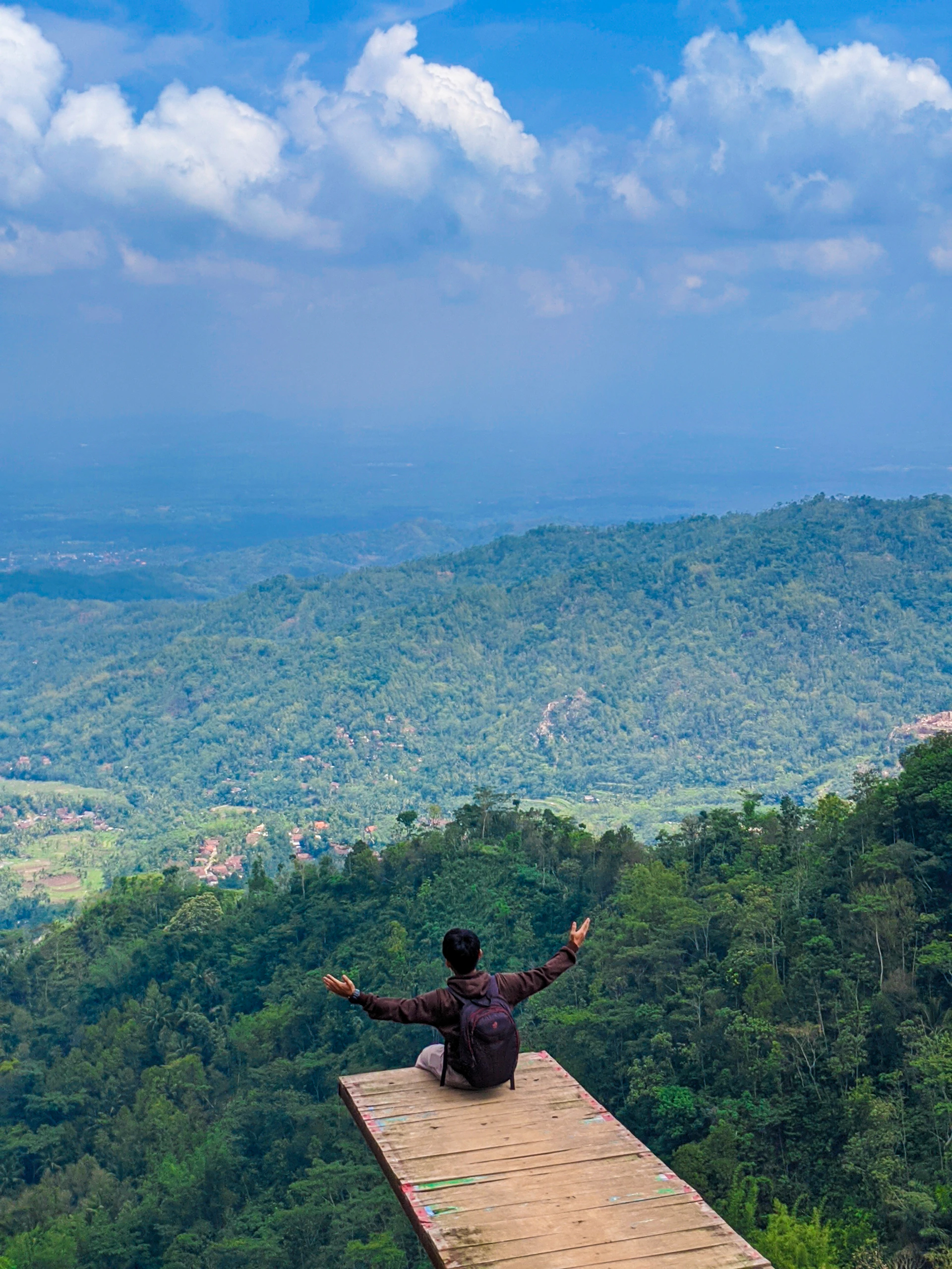 man sitting on dock on hill