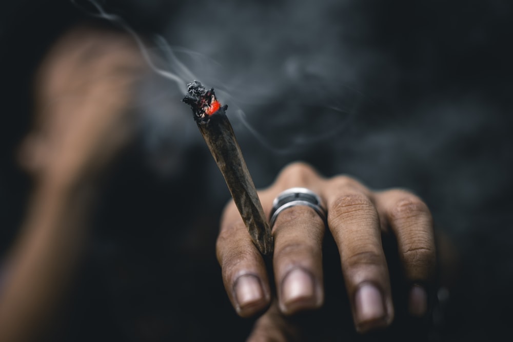 persona que lleva anillo y sostiene un porro