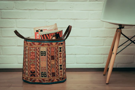 multicolored woven bag holding magazines