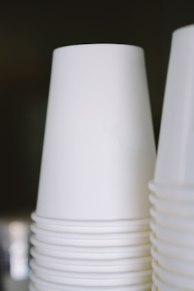 Stack of white disposable food containers with blue accents on a clean white background