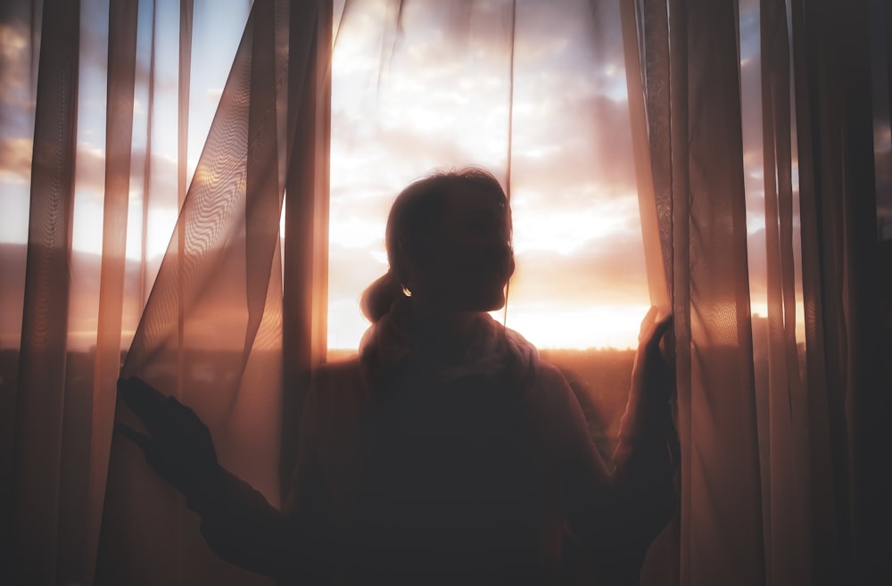 silhouette of person in front of window