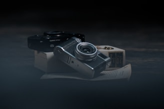 A quiet studio corner with vintage cameras and unfinished sketches on a wooden table.