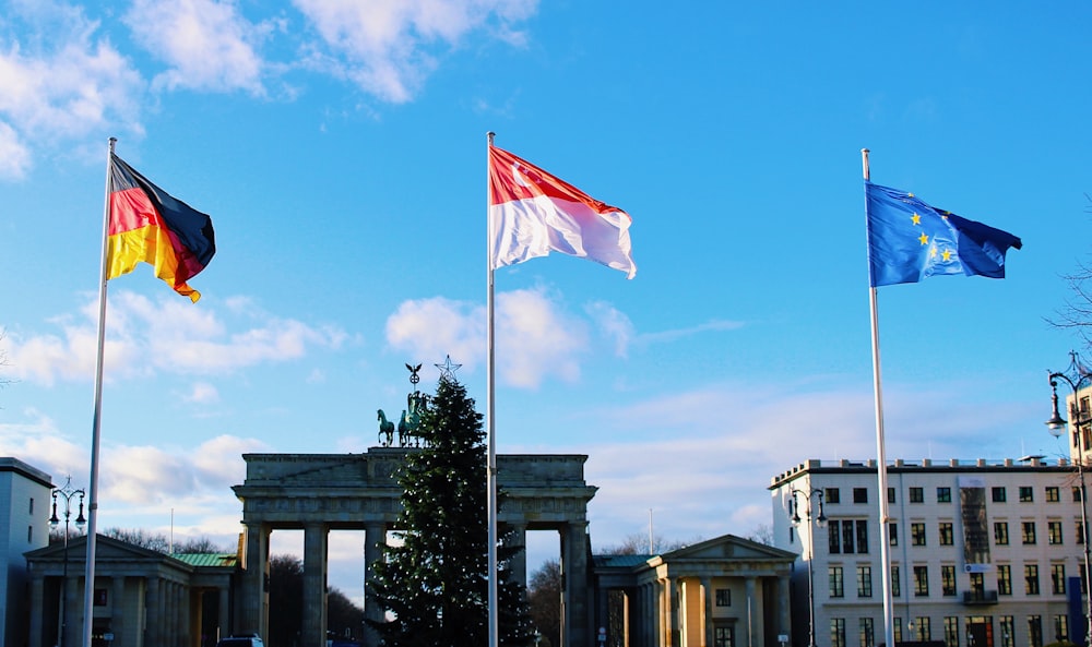 shallow focus photo of three assorted flags