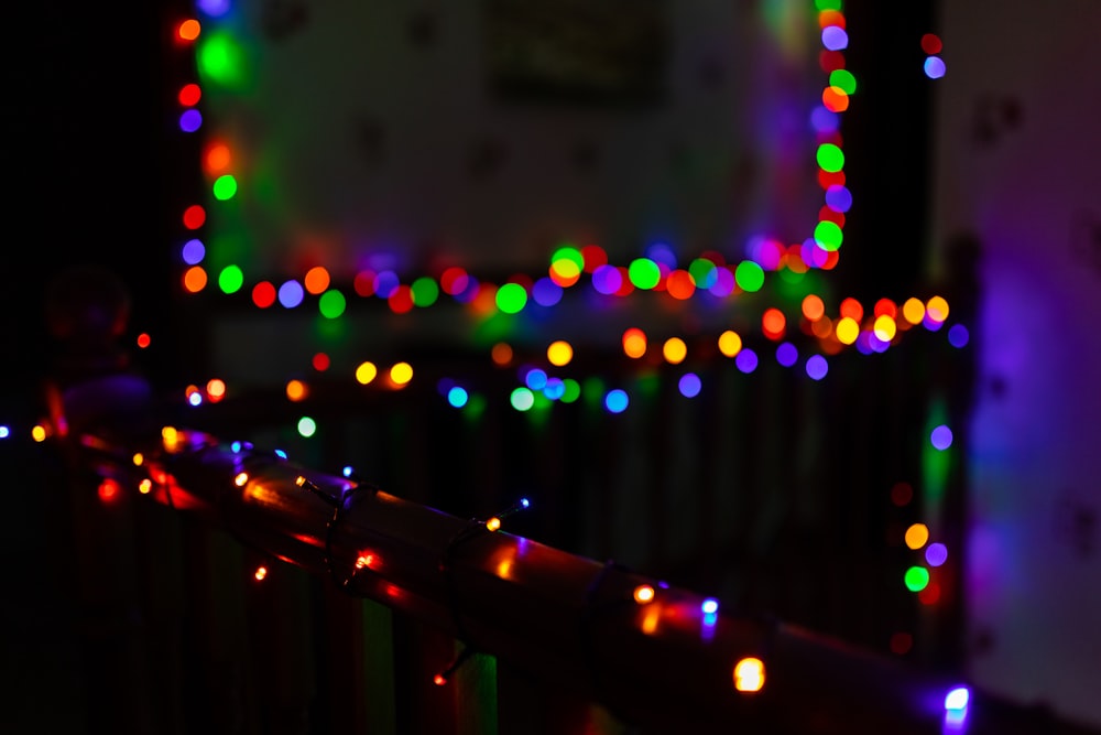 a fence covered in christmas lights in a dark room