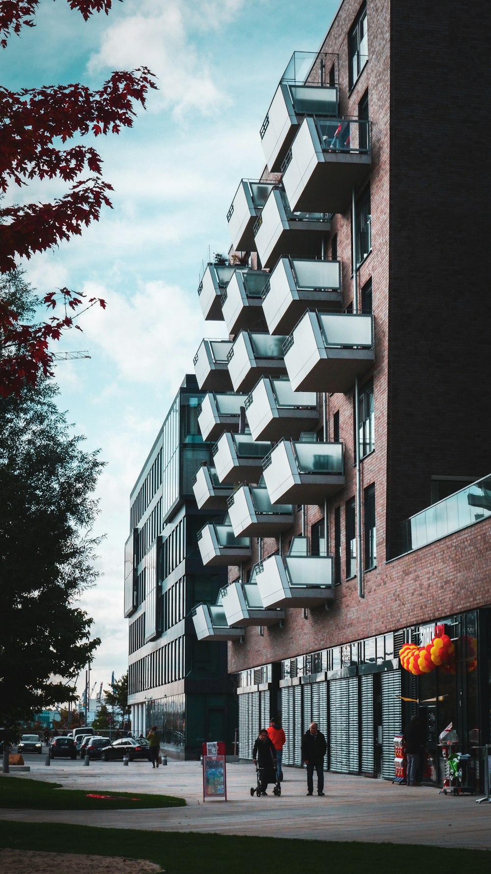 people near parked cars beside building during day