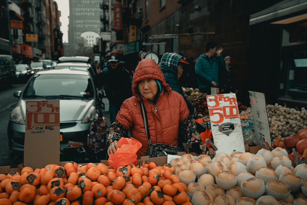 Woman selling fruits near park vehicle on street during day time