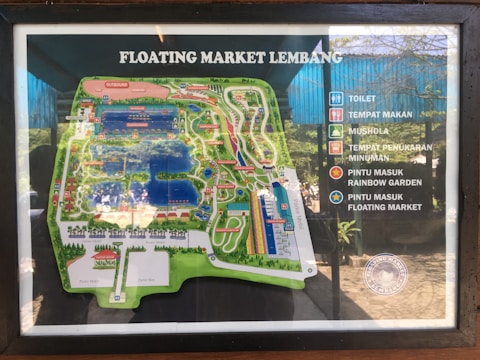 A detailed map of Floating Market Lembang is displayed, highlighting various attractions and facilities. There are icons indicating locations such as toilets, dining areas, a prayer room, beverage exchange points, and entrance points to the Rainbow Garden and the floating market itself.