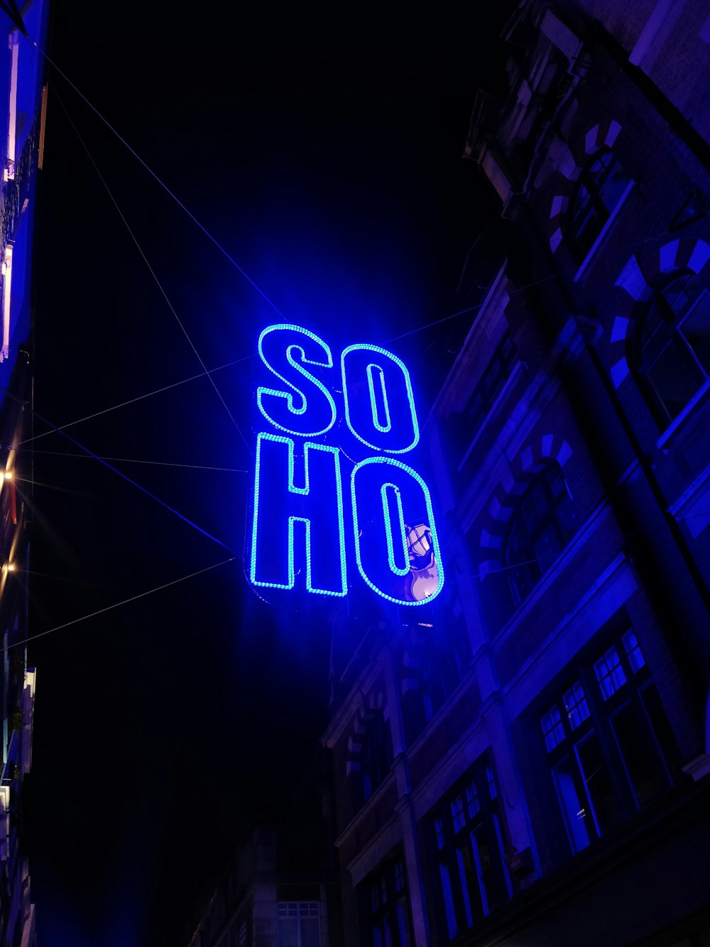 blue Soho LED sign outside building during night time