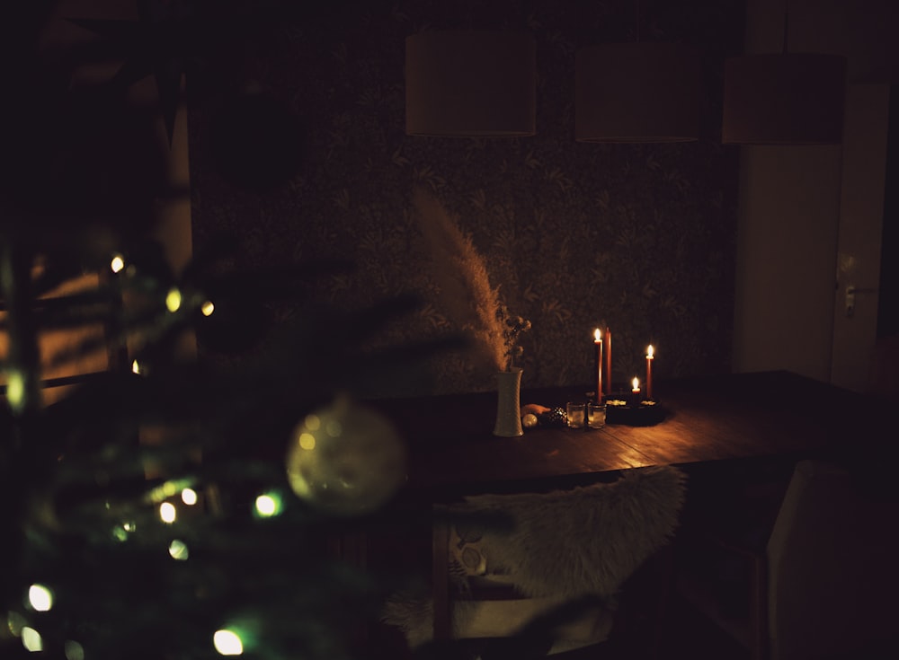 a lit candle on a table in a dark room