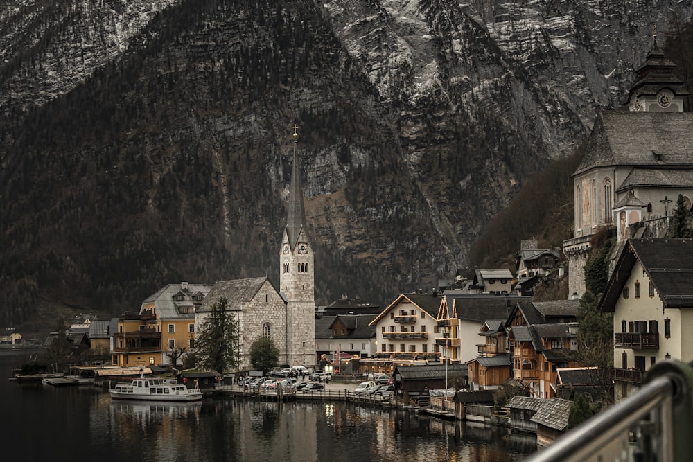 Un pequeño pueblo en un lago con montañas al fondo