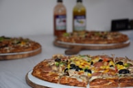 An overhead shot of a variety of pizzas arranged on a wooden table.