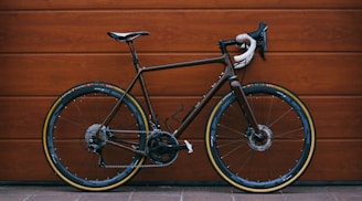 black road bike against wooden wall