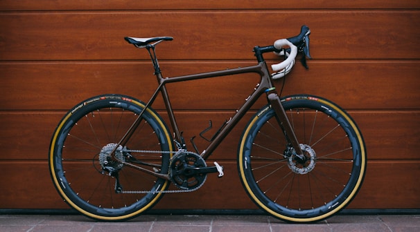 black road bike against wooden wall
