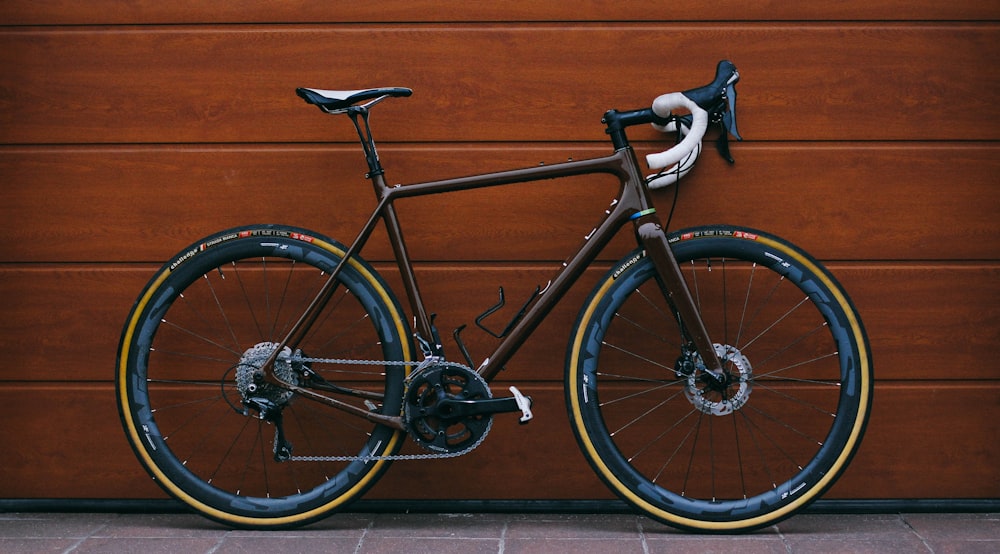 vélo de route noir contre un mur en bois