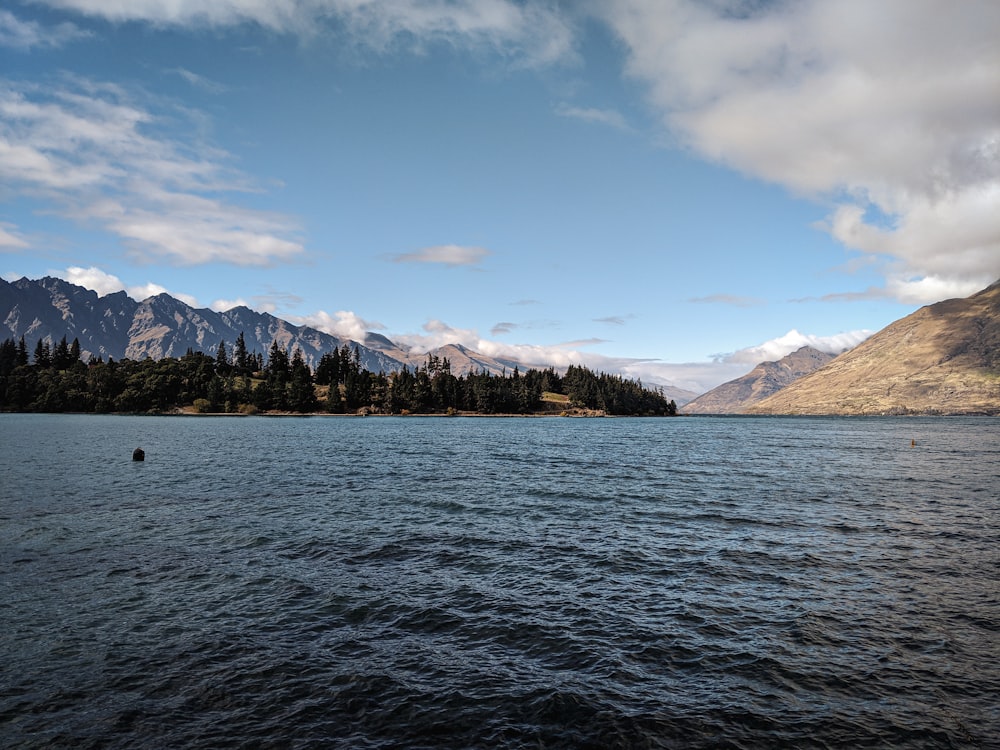 calm body of water under cloudy sky