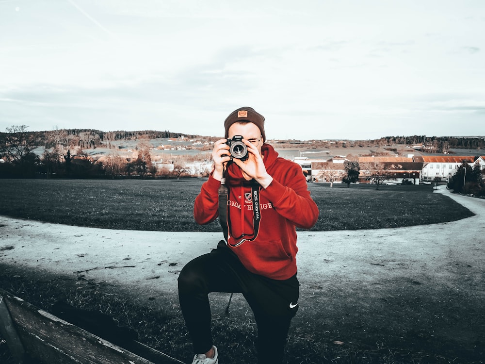 man using camera on field during day