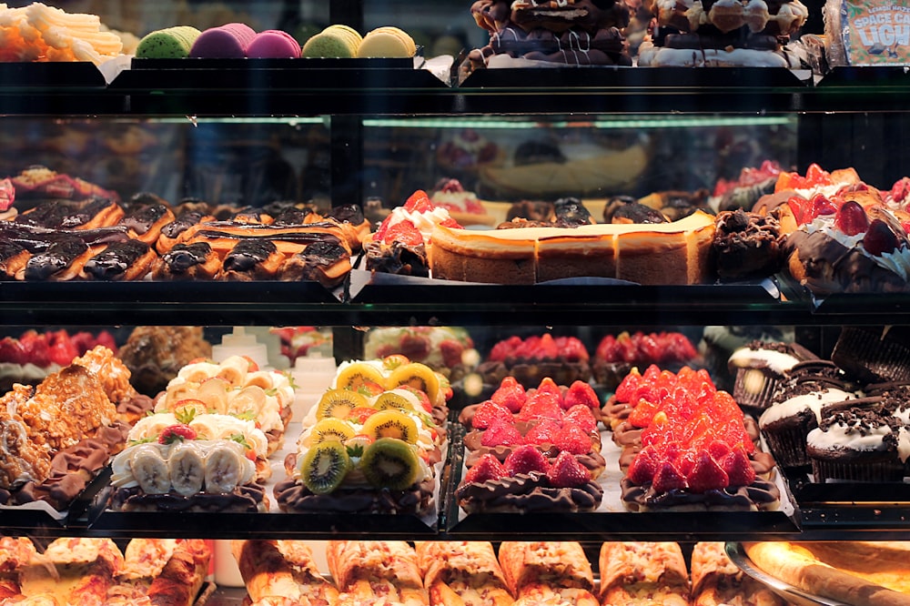 assorted cakes displaying in glass cabinet