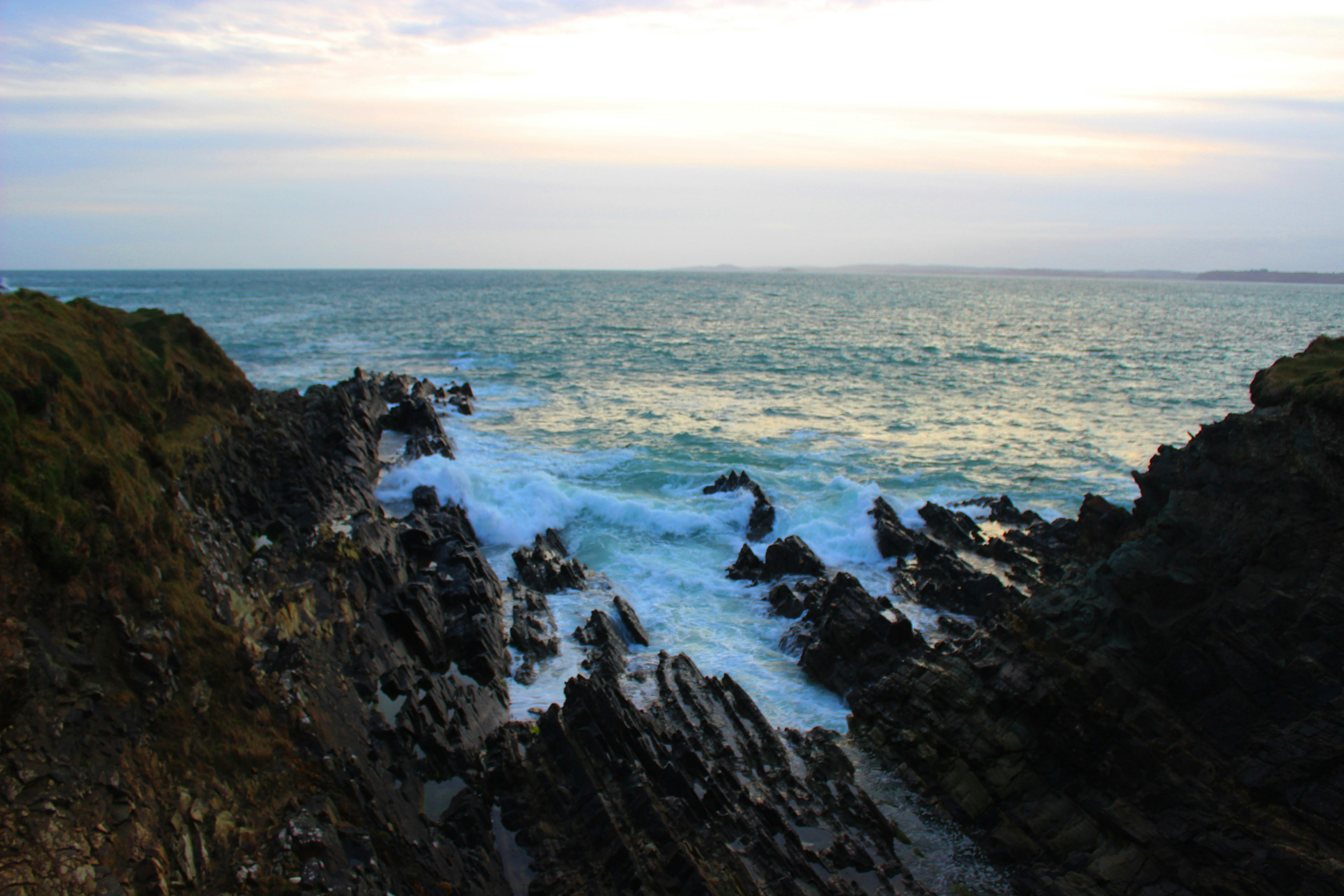 cliff viewing blue sea under white and blue sky, view over he wild atlantic way in Ireland
