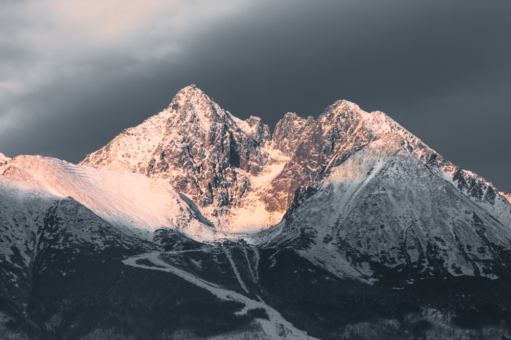 summit view of mountain covered with snow under gray sky