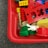 A collection of colorful building blocks, including red, yellow, green, and blue pieces, are scattered in a red plastic container. A small white toy figure with rabbit ears is visible among the blocks.