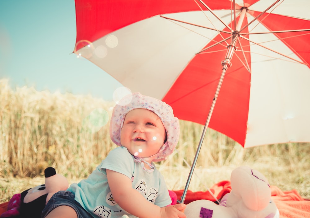 baby holding umbrella during daytime