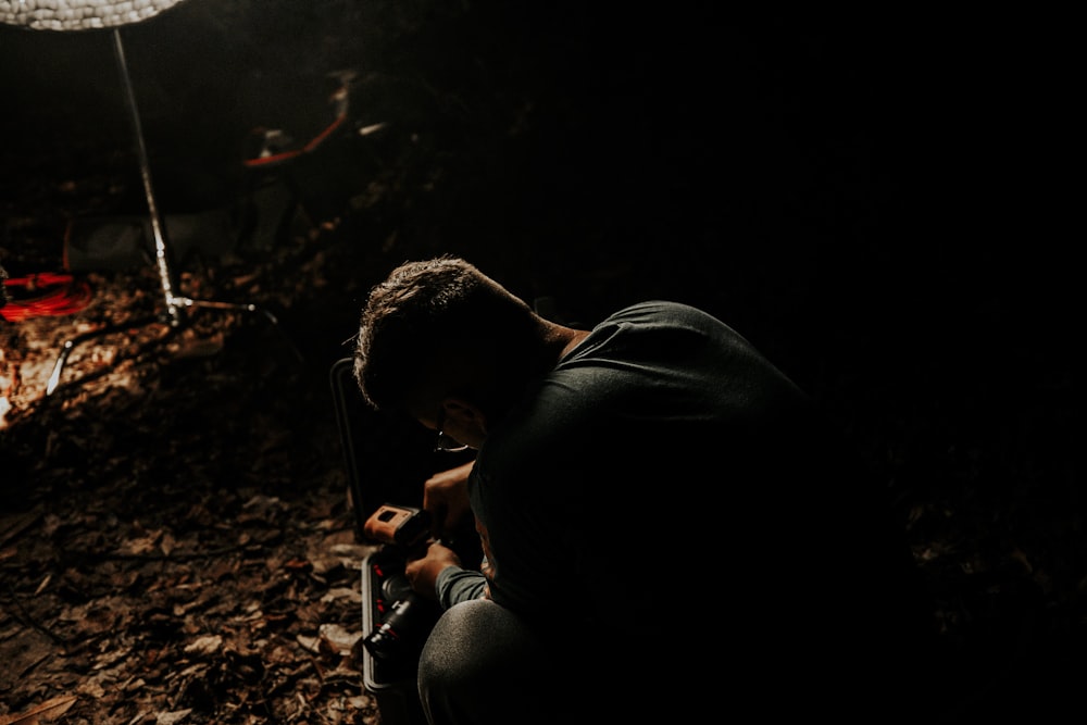 a man kneeling down in a dark room