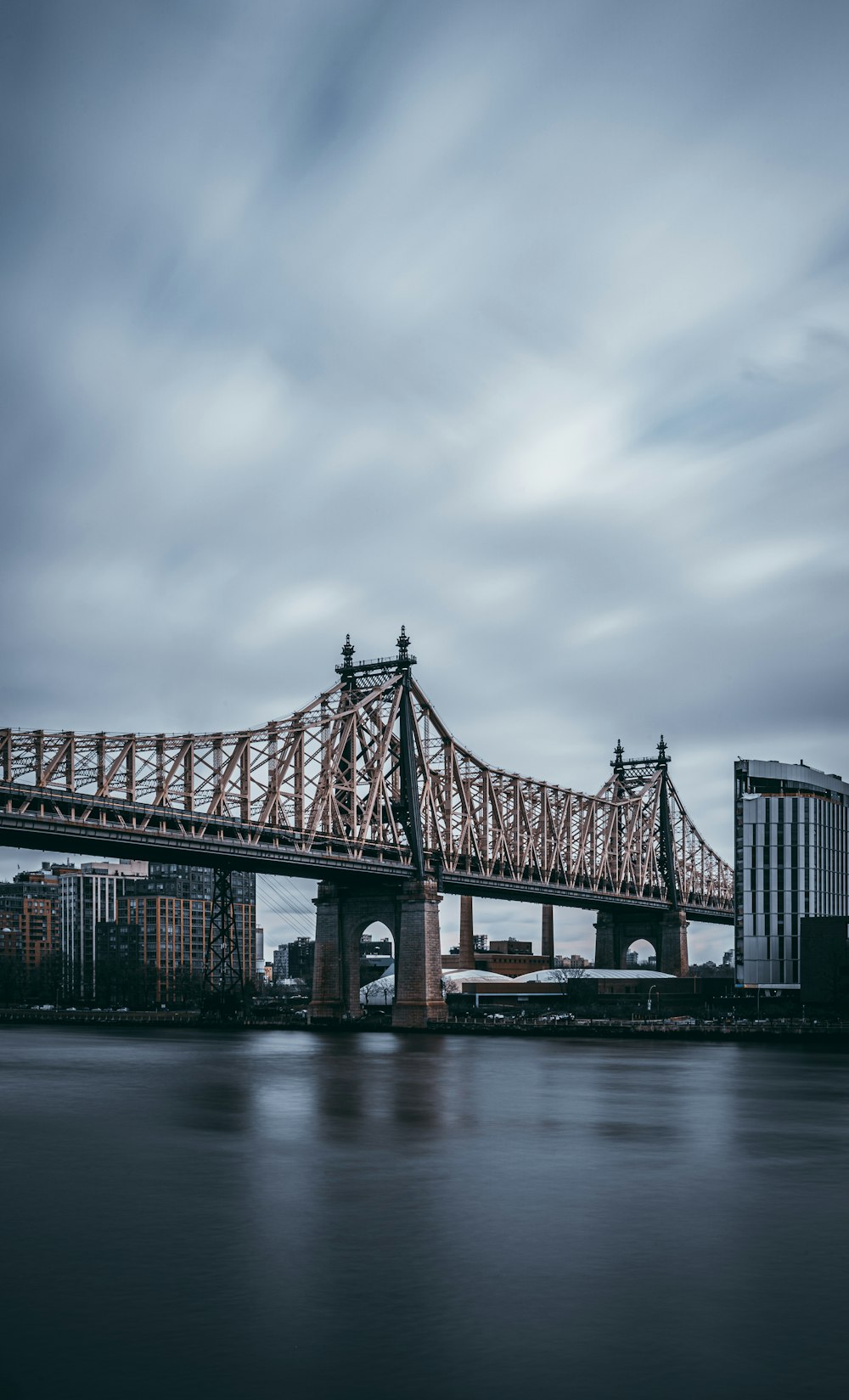 shallow focus photo of bridge under cloudy sky