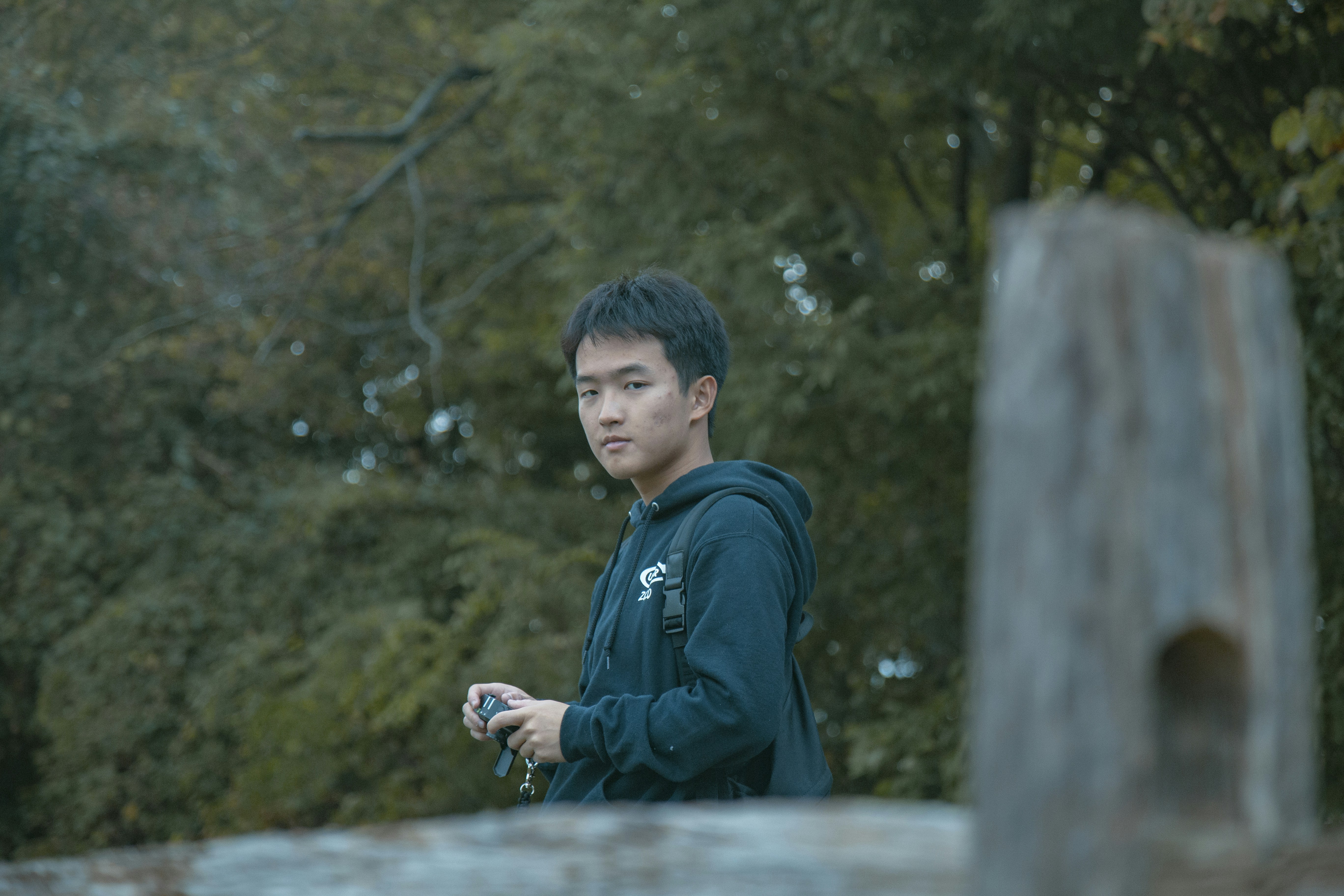 man holds camera near bridge