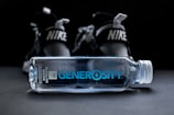 clear Generosity water bottle beside Nike shoes