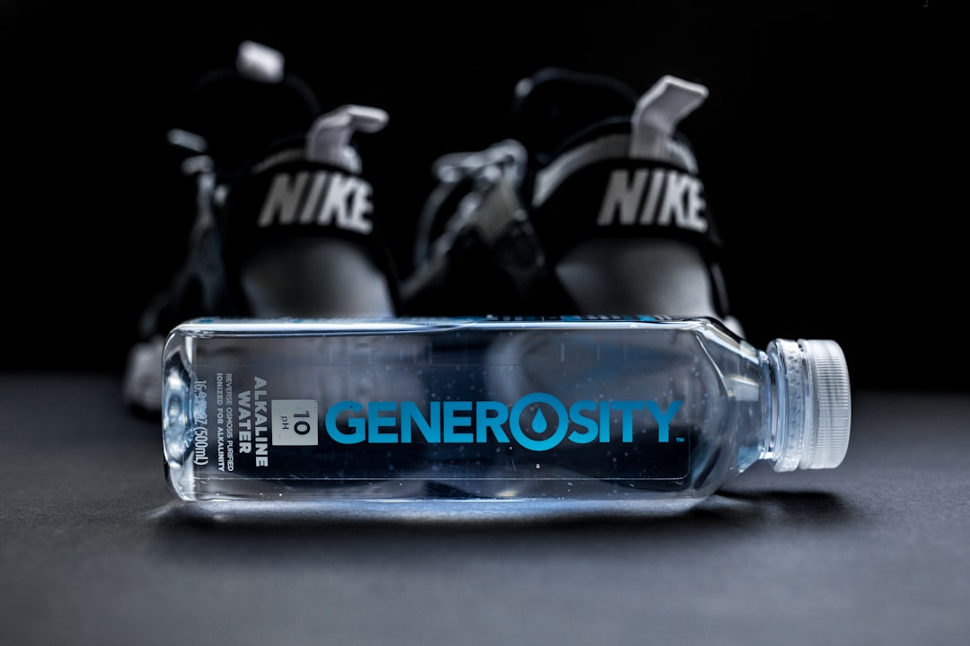 clear Generosity water bottle beside Nike shoes