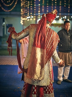 man in red and brown sherwani dress