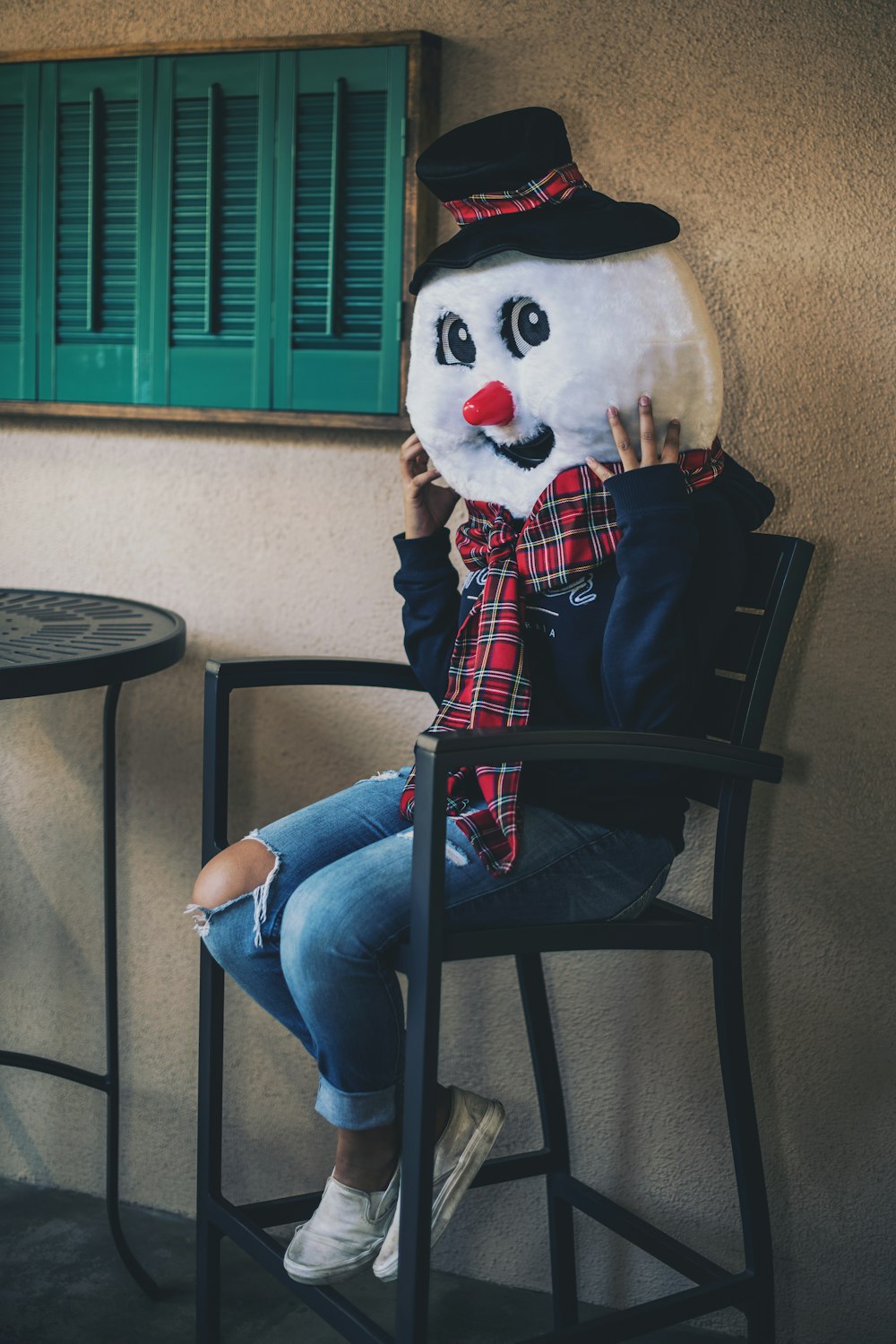 woman sitting on black chair while wearing white snowman head mascot