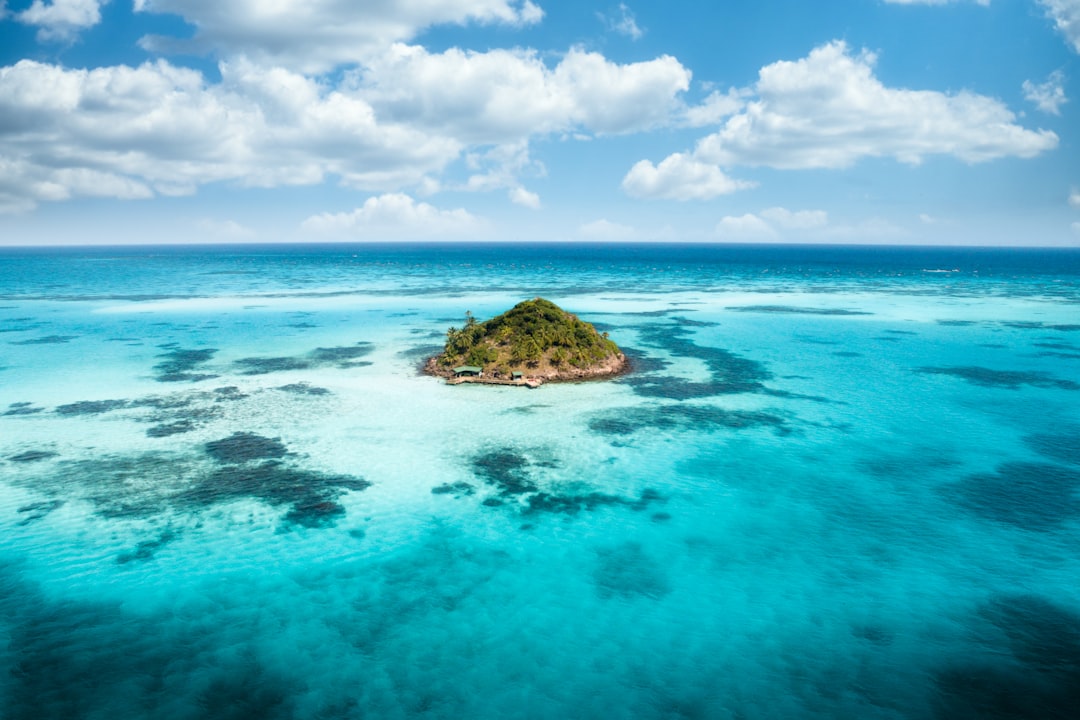 landscape photography of sea with little island between, Drone shot of tropical island and blue clear water in Providenc