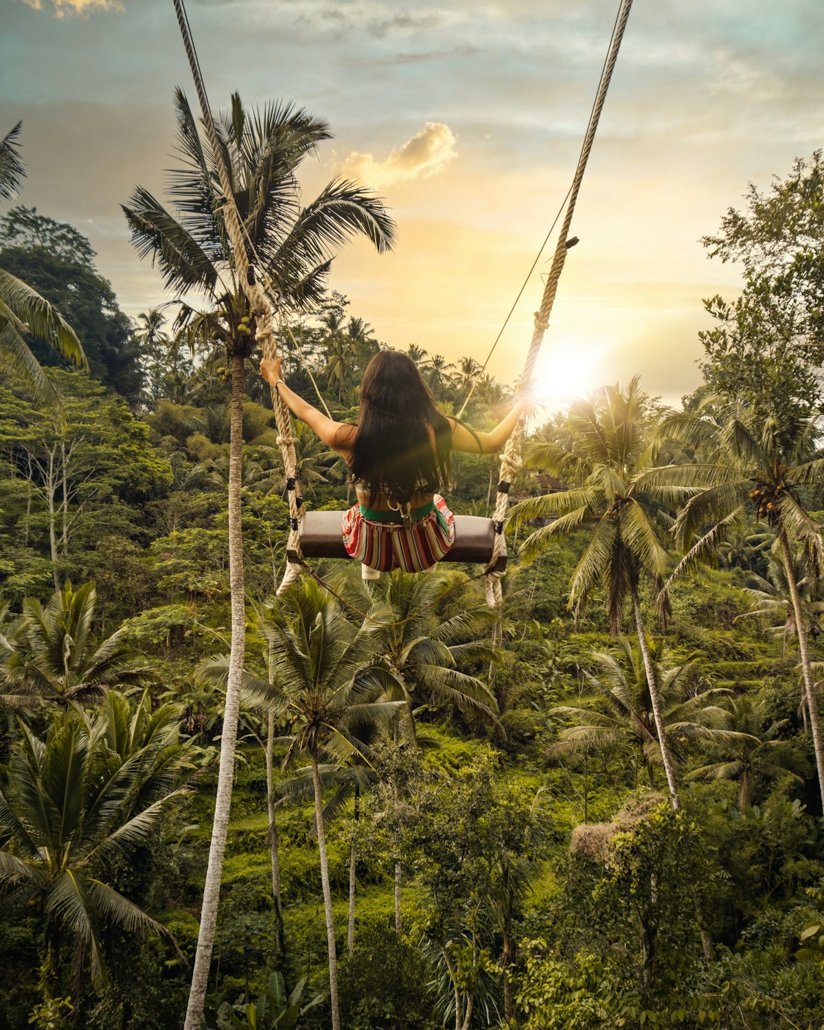 A woman on a jungle swing above the Tegalalang rice terraces in Ubud